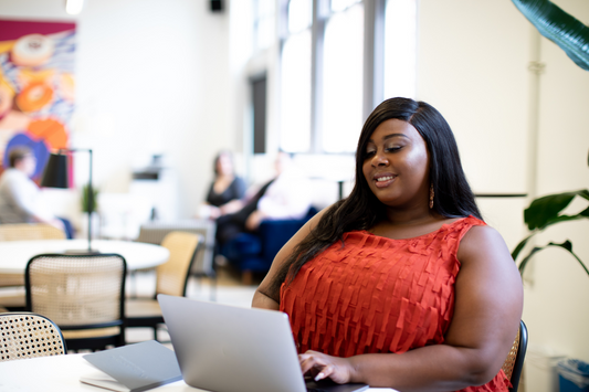 plus size black woman sitting with her computer typing a novel